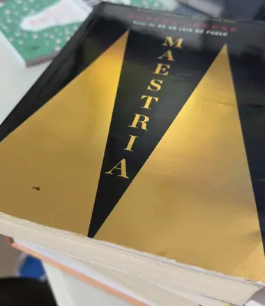 Exemplar de Maestria, de Robert Greene, com capa preta e dourada, fotografado por Carlos Cezare
